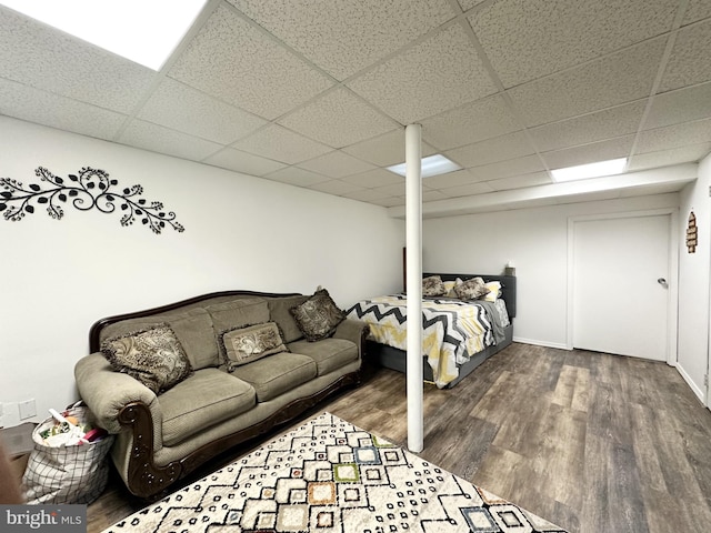 bedroom with a paneled ceiling and wood finished floors