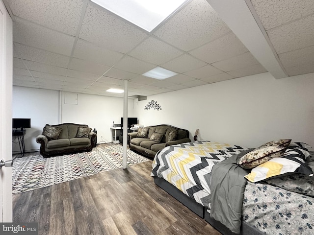 bedroom with a drop ceiling and wood finished floors