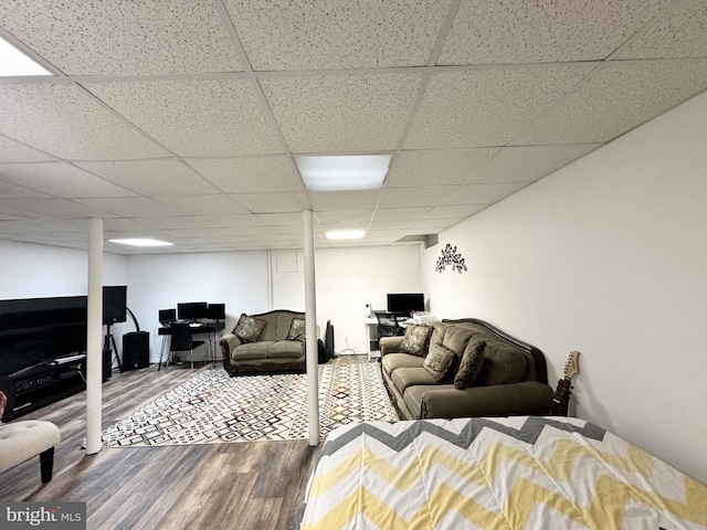 living area featuring a drop ceiling and wood finished floors