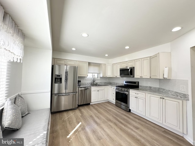 kitchen featuring light wood finished floors, recessed lighting, appliances with stainless steel finishes, and a sink