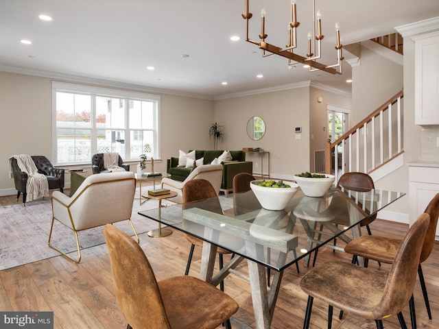 dining room with ornamental molding, recessed lighting, light wood finished floors, baseboards, and stairs