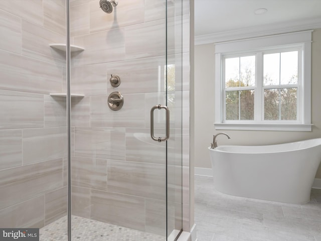 bathroom with a stall shower, crown molding, and a freestanding tub