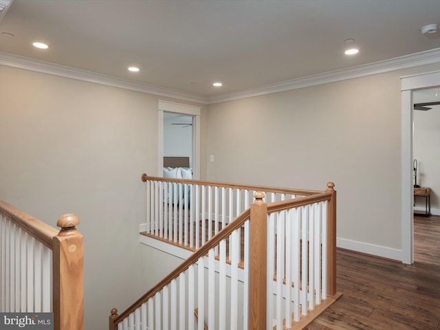 corridor with crown molding, wood finished floors, an upstairs landing, and baseboards