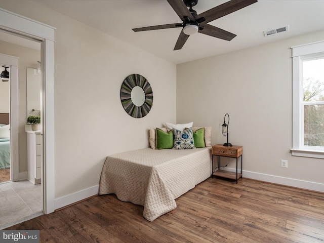 bedroom with wood finished floors, visible vents, and baseboards