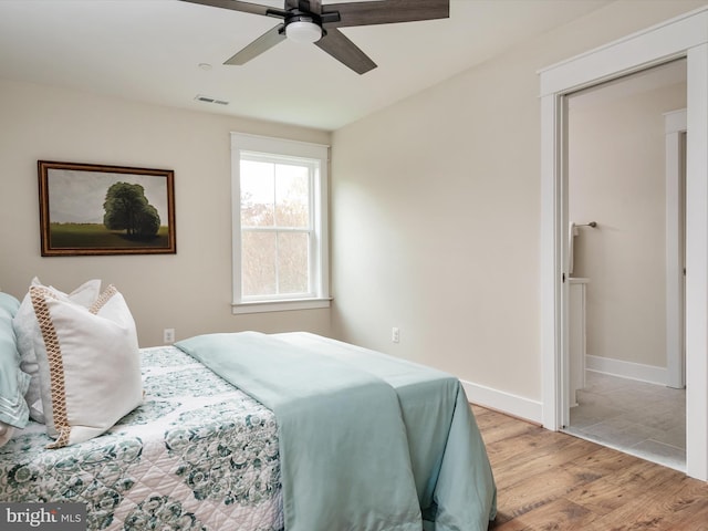 bedroom featuring light wood-style flooring, baseboards, visible vents, and ceiling fan