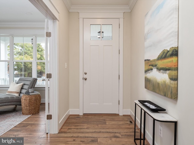 foyer entrance featuring baseboards, wood finished floors, and ornamental molding