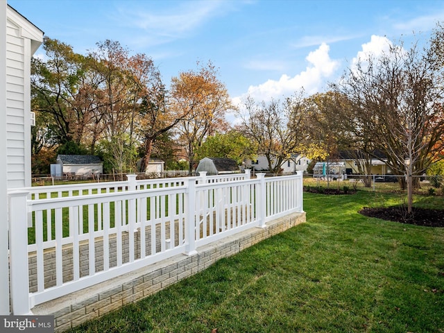 view of yard with an outdoor structure, a storage unit, and a fenced backyard