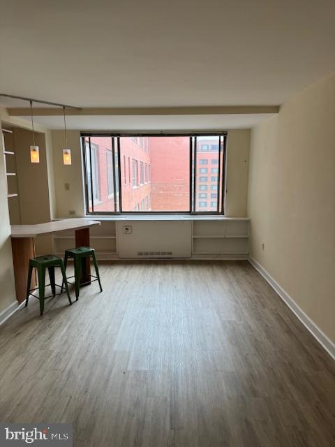 unfurnished room featuring wood finished floors and baseboards