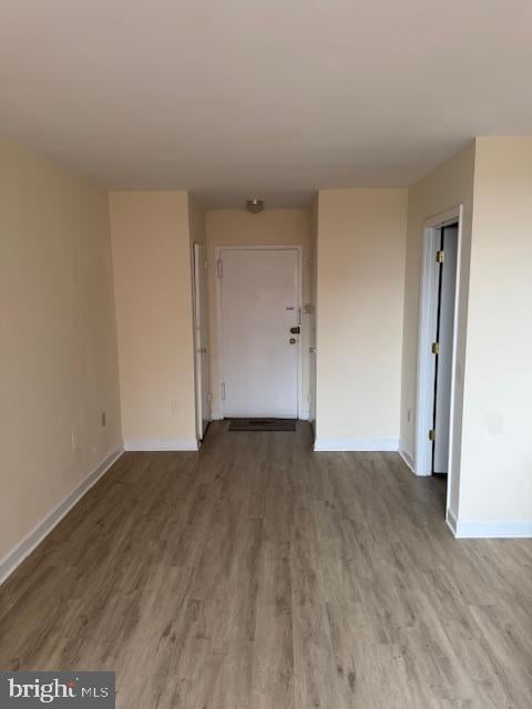 spare room featuring baseboards and wood finished floors