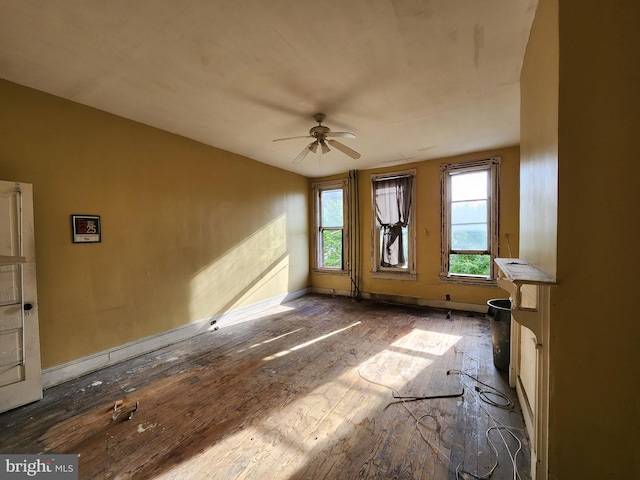 spare room featuring wood finished floors, a ceiling fan, and baseboards