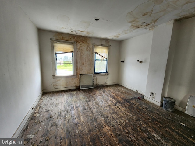 empty room with hardwood / wood-style floors and baseboards