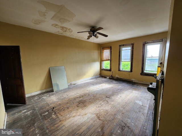 empty room featuring ceiling fan, baseboards, and hardwood / wood-style flooring