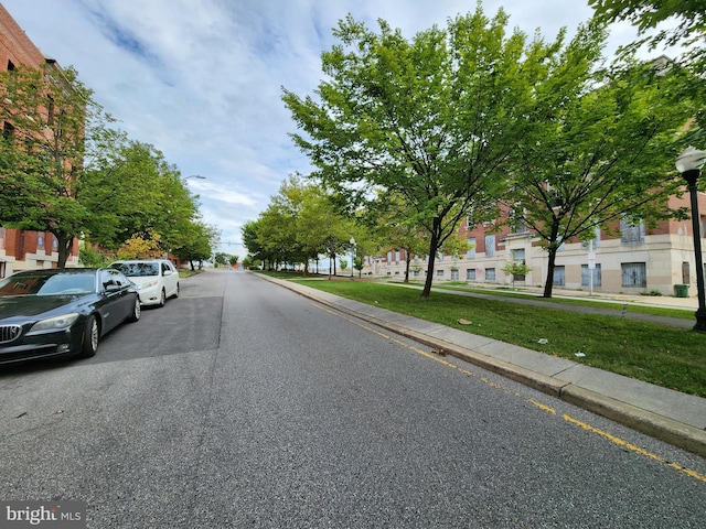 view of road with a residential view, curbs, street lighting, and sidewalks