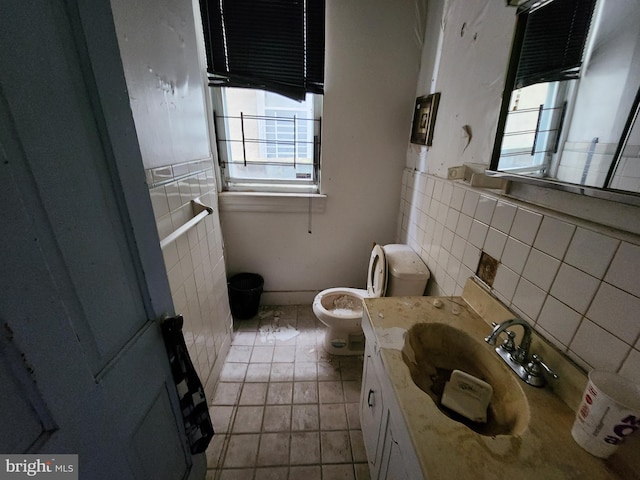 half bathroom featuring vanity, tile walls, and toilet