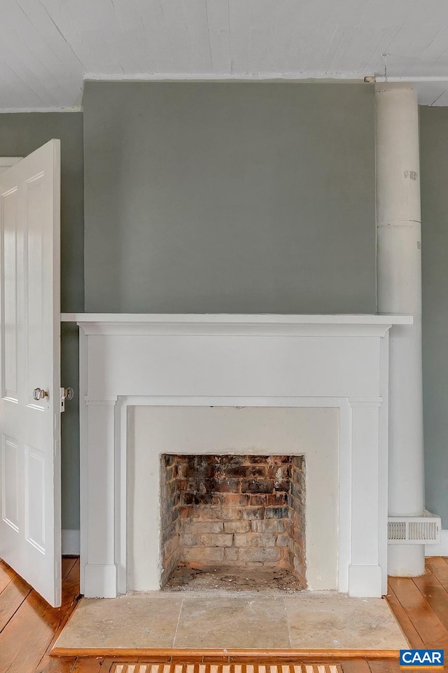 details featuring a fireplace with flush hearth and wood finished floors