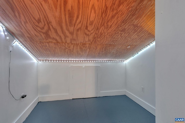 bonus room featuring baseboards, wood ceiling, and finished concrete floors