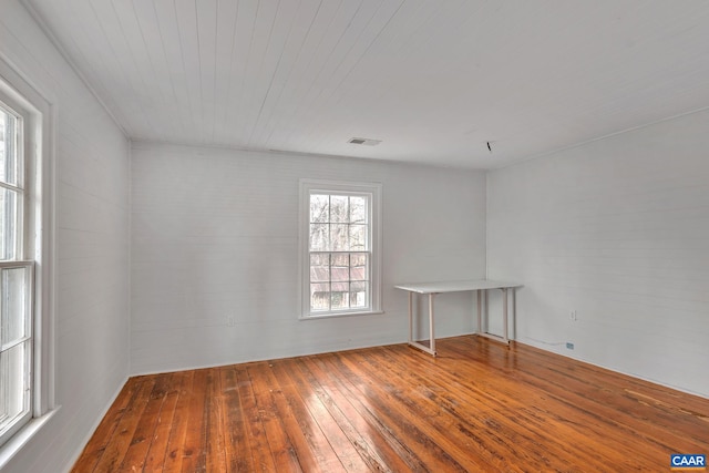 empty room with hardwood / wood-style flooring and visible vents