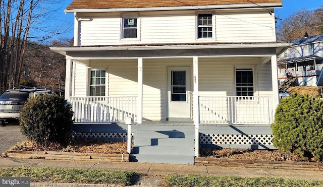 view of front facade with a porch and a shingled roof