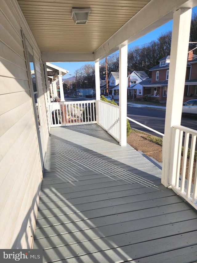 wooden deck featuring covered porch and a residential view