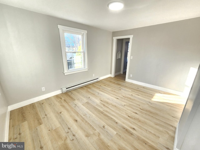 681 Fayette St, Cumberland, MD 21502 - empty room with a baseboard heating unit, light wood-style floors, and baseboards
