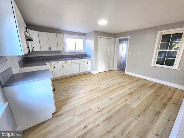 681 Fayette St, Cumberland, MD 21502 - kitchen featuring white cabinets, baseboards, light wood-type flooring, and a sink