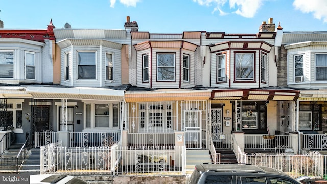 view of property with a fenced front yard and covered porch