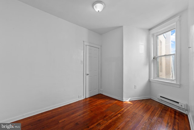 spare room featuring wood-type flooring, baseboards, and a baseboard radiator