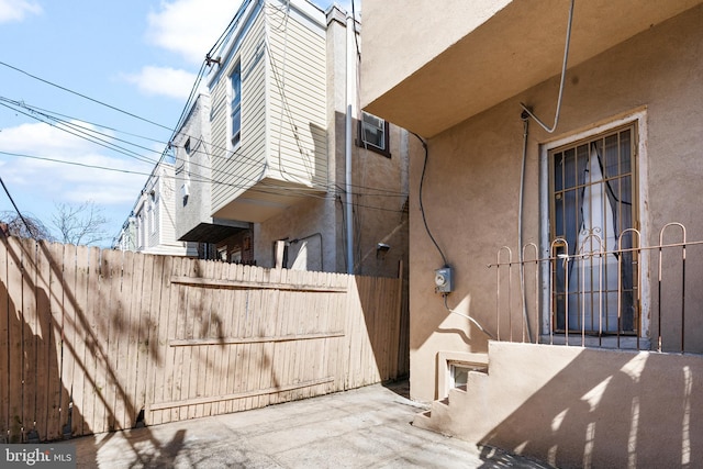 view of side of home with fence and stucco siding