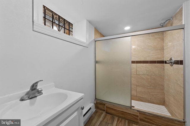 full bathroom featuring a sink, baseboard heating, and a shower stall