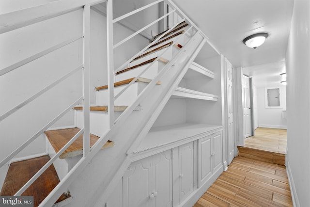 staircase featuring baseboards and wood finished floors