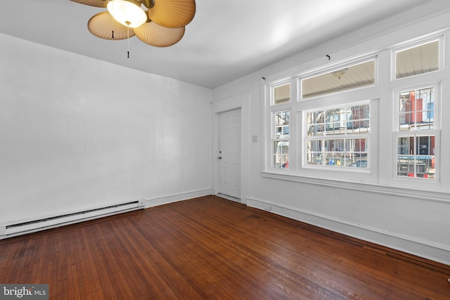 spare room featuring baseboard heating, a ceiling fan, baseboards, and hardwood / wood-style floors