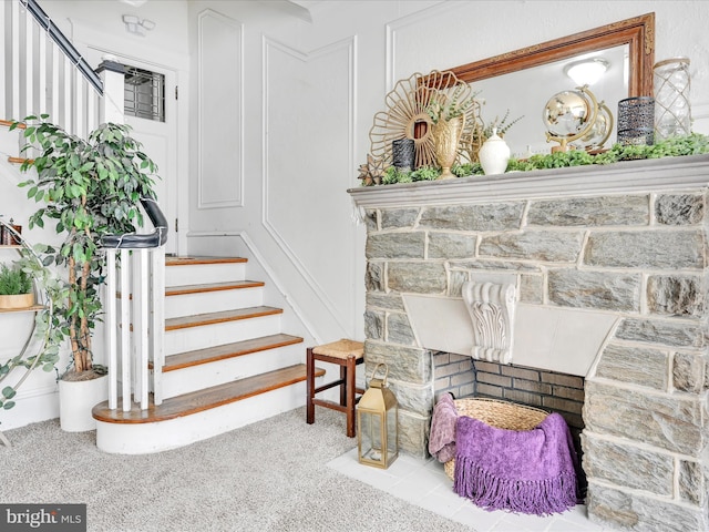 interior space with carpet flooring and a stone fireplace