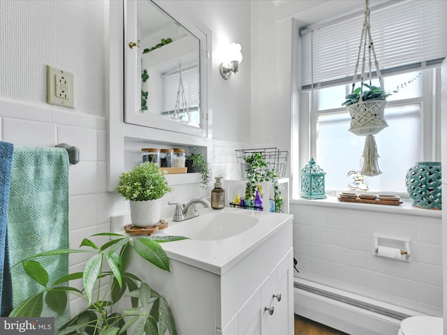 bathroom featuring toilet, tile walls, wainscoting, and vanity