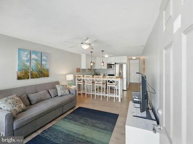 living area featuring ceiling fan and light wood-style flooring