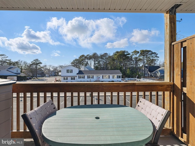 wooden terrace featuring outdoor dining area and a residential view