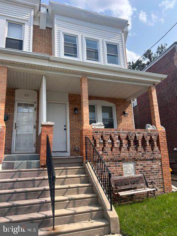 view of front of house with brick siding and a porch