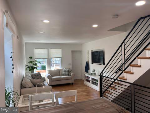 living room with stairway, recessed lighting, and wood finished floors