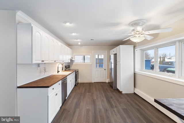 kitchen with a wealth of natural light, backsplash, white cabinetry, and stainless steel appliances