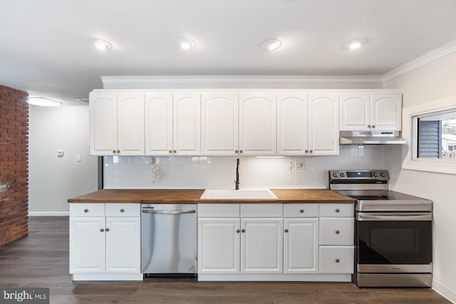 kitchen with a sink, stainless steel appliances, wooden counters, and under cabinet range hood