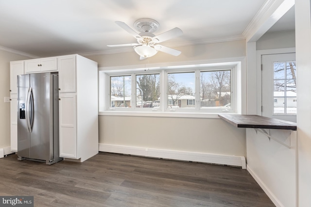 unfurnished dining area with baseboards, dark wood-type flooring, ceiling fan, and crown molding