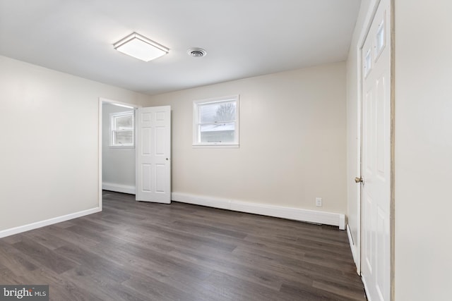 unfurnished bedroom featuring dark wood finished floors, visible vents, and baseboards