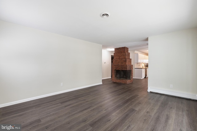 unfurnished living room with baseboards, visible vents, a baseboard radiator, a fireplace, and dark wood-type flooring