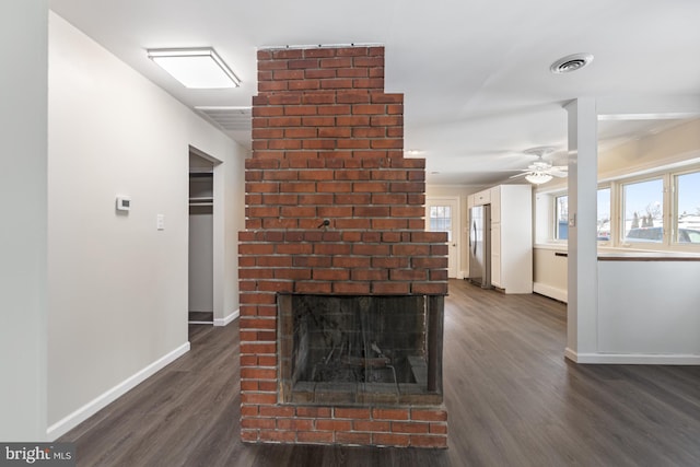 unfurnished living room with dark wood finished floors, plenty of natural light, and baseboards