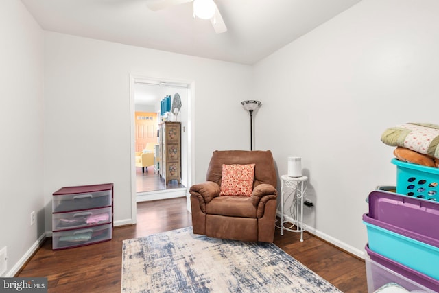 living area featuring ceiling fan, baseboards, and wood finished floors