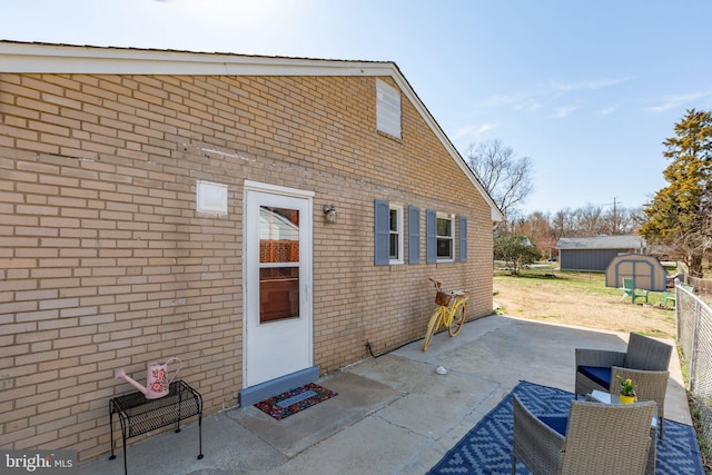 view of patio with an outbuilding, a shed, and fence