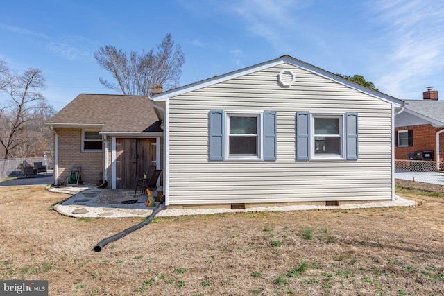 view of home's exterior featuring fence, a chimney, a yard, crawl space, and a patio