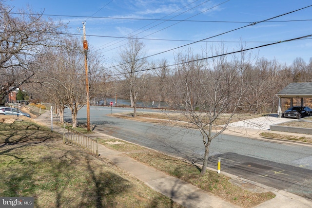 view of road featuring sidewalks, curbs, and traffic signs