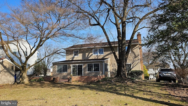 view of front of house with a front yard and a chimney