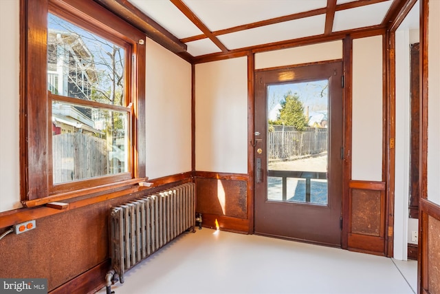 unfurnished sunroom featuring radiator and a healthy amount of sunlight