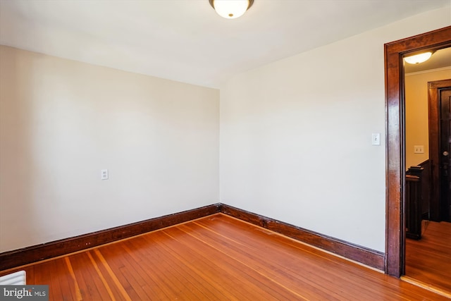 spare room featuring baseboards and hardwood / wood-style floors